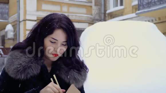 年轻的韩国人在下雪时在街上吃面条视频的预览图