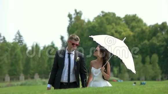新郎和新娘带着雨伞视频的预览图