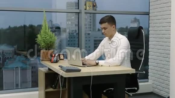 穿着白衬衫的商人在办公室工作手提电脑视频的预览图