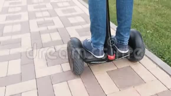 人双腿穿着运动鞋滚动在陀螺滑板车在铺路视频的预览图