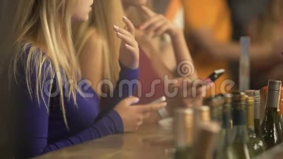 很多年轻人拿着小玩意在酒吧闲逛点酒精饮料视频的预览图