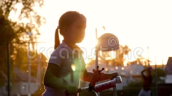 日落时分年轻女孩骑着现代自行车在公园里近距离拍摄视频的预览图