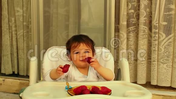 小男孩在高椅上吃草莓视频的预览图
