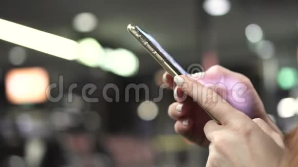 女子在机场候机楼使用智能手机手举特写视频的预览图