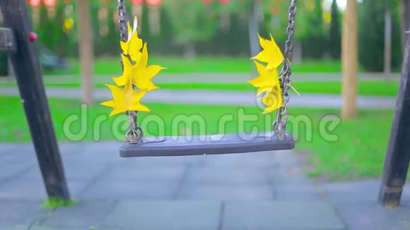 秋日公园里黄叶缓缓摆动的特写秋千视频的预览图