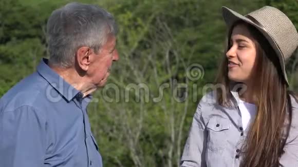 快乐少女与年长祖父交谈视频的预览图
