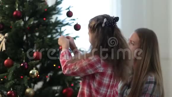 女孩帮妈妈装饰家庭圣诞树视频的预览图