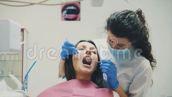 一个年轻的女孩被录取去看牙医在这段时间里她张开嘴了解医生视频的预览图