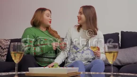 年轻女孩和坐在沙发上的胖女朋友聊天视频的预览图