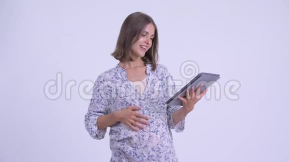 快乐的年轻孕妇用数码平板电脑思考视频的预览图