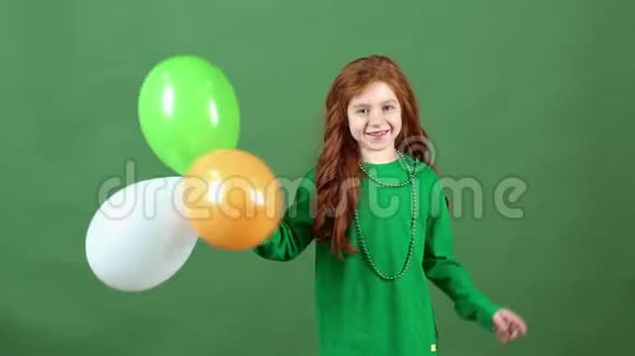女孩红发庆祝圣帕特里克节绿墙背景站着气球视频的预览图