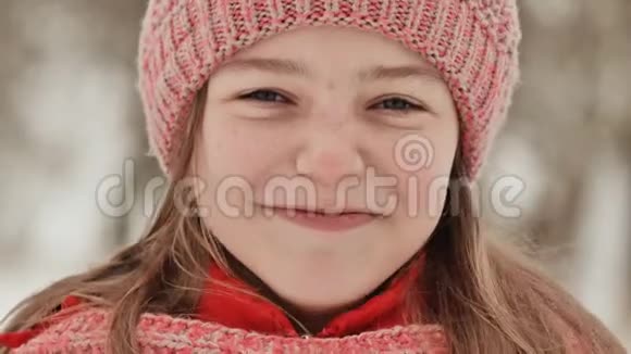 冬天在树林里长雀斑的年轻女学生的肖像女孩用手摸鼻子视频的预览图