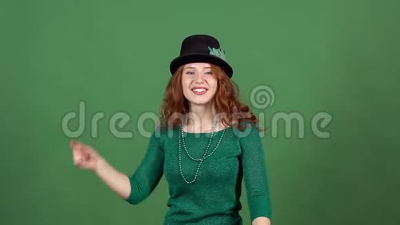 年轻女子庆祝圣帕特里克节绿墙投掷帽子视频的预览图