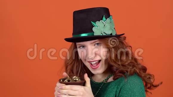 年轻女子庆祝圣帕特里克节日戴着帽子手里拿着钱视频的预览图