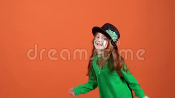 女孩红发庆祝圣帕特里克节橙色背景跳舞气球视频的预览图