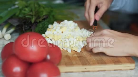 在木板上用刀切煮鸡蛋把煮好的手合上食物概念视频的预览图