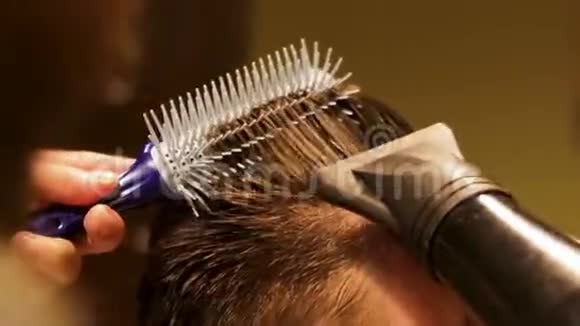 面目全非的专业理发师把他的男客户的头发弄干特写视频的预览图