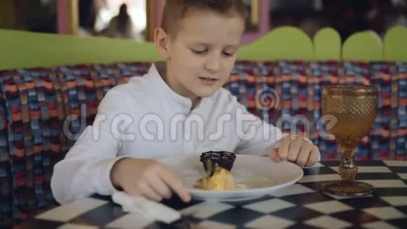 英俊的男孩微笑着看着美味的甜点展示4K视频的预览图