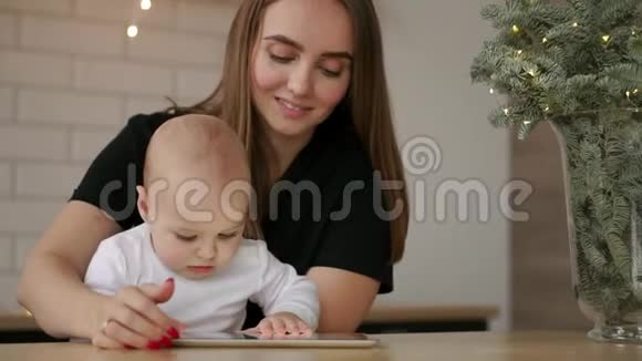 家庭技术和母性概念快乐的年轻母亲带着小宝宝和平板电脑在家视频的预览图