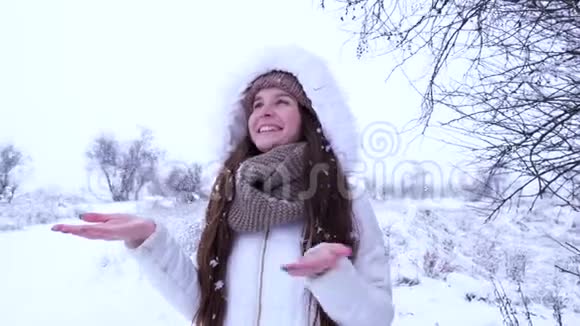 快乐的女人手抓着降雪在冬天微笑视频的预览图