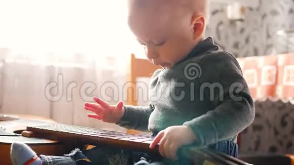 一个小男孩在家玩吉他视频的预览图