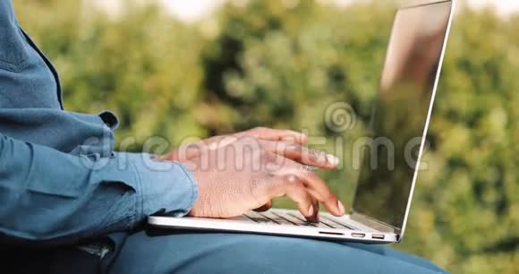 把年轻的黑人手收起来他穿着衬衫在笔记本电脑键盘上打字自由职业概念视频的预览图