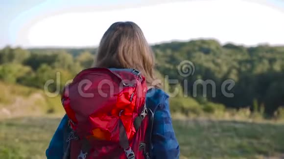 美丽的女孩带着袋子旅行在大自然中徒步旅行视频的预览图