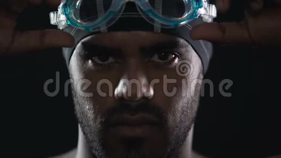 西班牙游泳运动员戴着护目镜和看着镜头严肃的脸运动视频的预览图