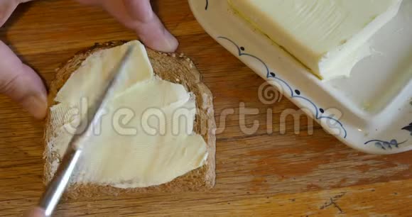 把黄油涂在一片全麦面包上视频的预览图