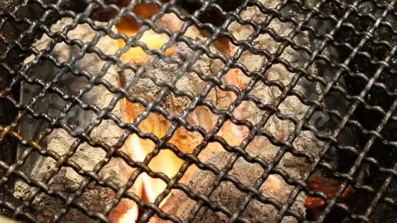 4K燃煤在烤肉架和灼热的煤下的炉子里燃烧的红热的煤的特写镜头视频的预览图
