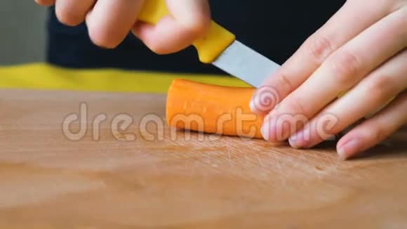 女人把胡萝卜切成薄片放在切割板上视频的预览图