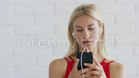 可爱的女性听音乐和使用智能手机视频的预览图