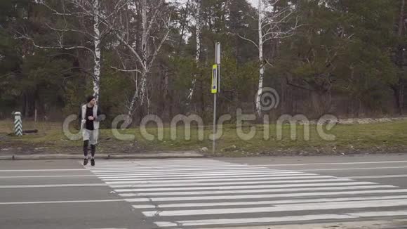 年轻运动员穿过马路停下来检查时间继续跑步视频的预览图
