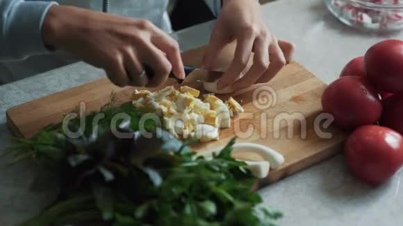 在木板上用刀切煮鸡蛋把女人的手收起来食物概念视频的预览图