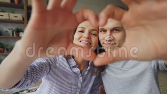 欢快的多民族夫妇用双手捧着心看着镜头微笑着的画像浪漫浪漫视频的预览图