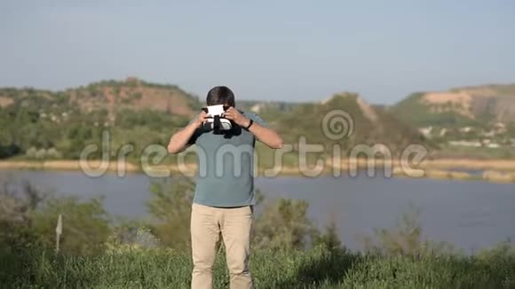 一个人站在湖边的背景上戴上虚拟现实头盔查看图片视频游戏全世界视频的预览图