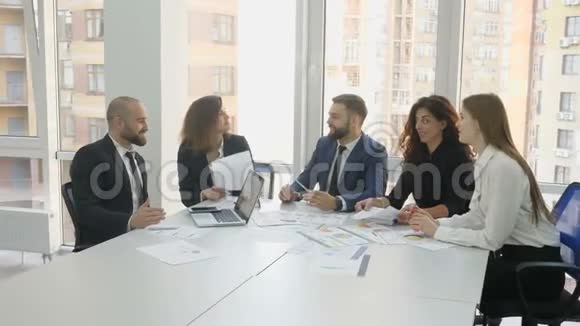 办公室工作人员一家大公司的员工两个年轻的男人和三个年轻的女人会议结束的男人摇动视频的预览图