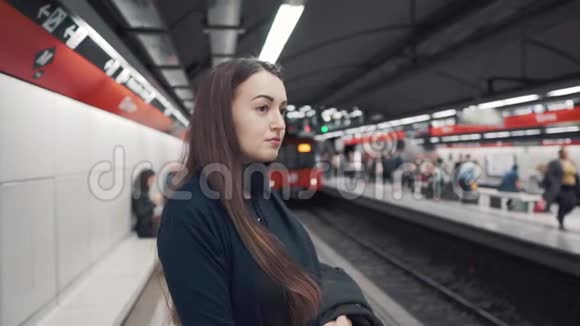 小女孩站在站台上等待火车到达视频的预览图