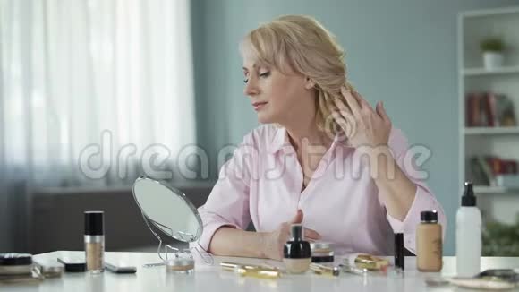 中年妇女照镜子后皮肤恢复程序视频的预览图