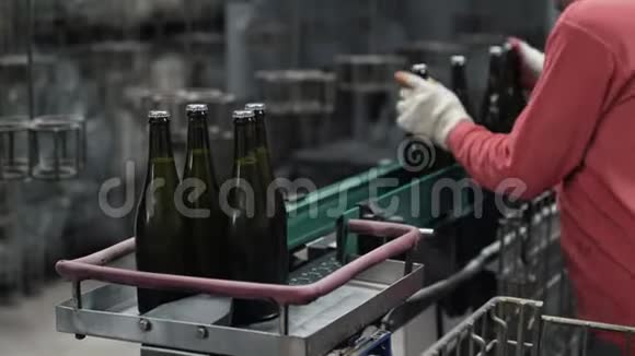 把工人的手举起来从传送带上拿走香槟瓶视频的预览图