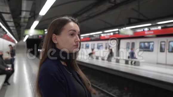 小女孩站在站台上等待火车到达视频的预览图