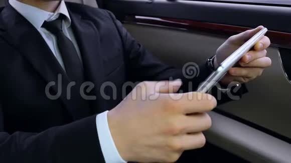 成功的商人坐在车里在他的平板电脑上滚动商业新闻视频的预览图