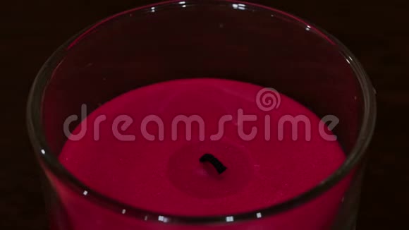 在尘土飞扬的玻璃里燃烧一支粉红色的蜡烛视频的预览图