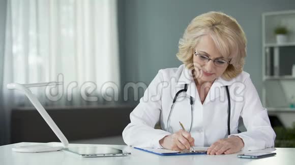 女医生在治疗病人前填写健康保险表格视频的预览图