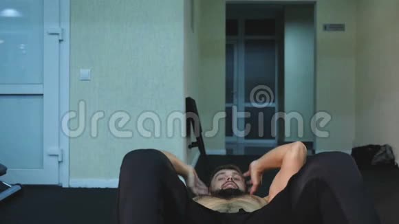 年轻男子摇摆出版社男子为平肚子做运动有吸引力的男子运动员在垫子上做运动视频的预览图