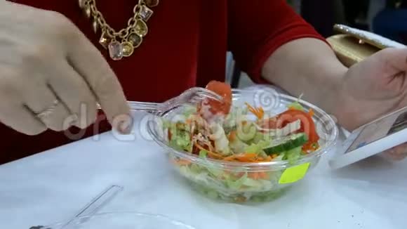 成人优雅的白种人女人坐在餐桌前吃美味的沙拉视频的预览图