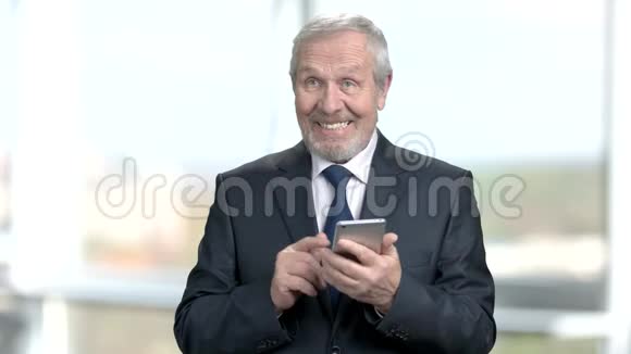 满意的老年商人智能手机视频的预览图