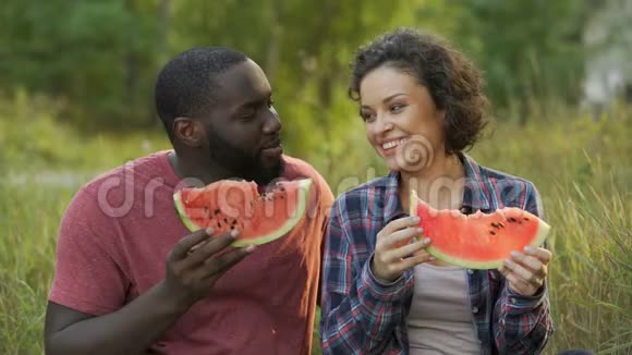 快乐的一对夫妇享受美味的西瓜大片有益的水果饮食视频的预览图