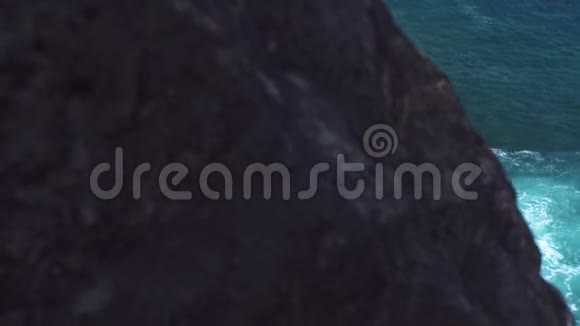 强大的海浪冲破岩石岛绿松石海浪随泡沫和浪花溅到石崖视频的预览图