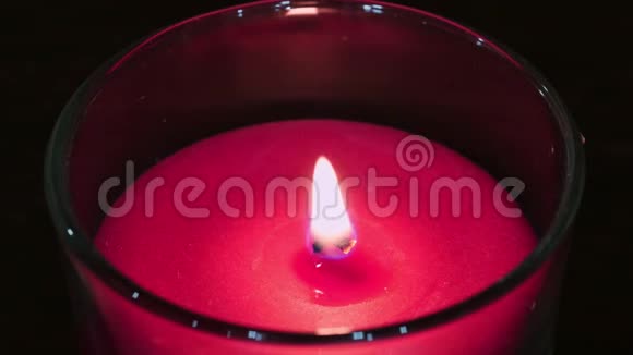 在尘土飞扬的玻璃中熄灭粉红色蜡烛的火焰视频的预览图
